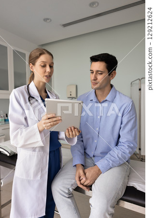 Positive young female doctor explaining electronic medical report 129212624