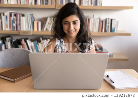 Woman immersed in work or study using laptop in workspace Woman immersed in work or study using laptop in workspace 129212678