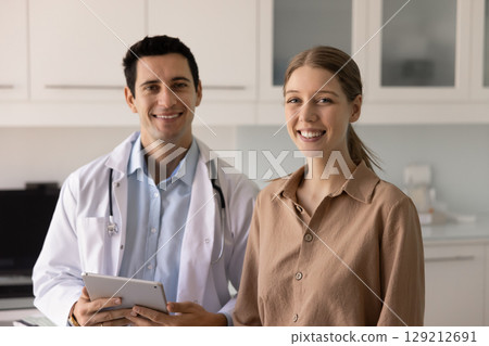 Positive male Latin doctor and young female patient posing together Positive male Latin doctor and young female patient posing together 129212691