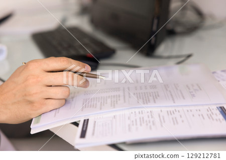 Hand of medical lab worker filling up paper form Hand of medical lab worker filling up paper form 129212781