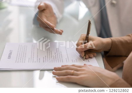 Commercial clinic female patient signing contract for healthcare service Commercial clinic female patient signing contract for healthcare service 129212802