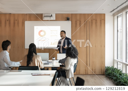 Busy mature male ceo mentoring diverse team in conference room 129212819