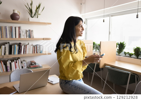 Businesswoman using smartphone distracted from workflow in modern coworking office Businesswoman using smartphone distracted from workflow in modern coworking office 129212928