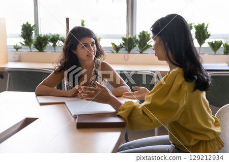 Two Indian women colleagues engaged in professional discussion 129212934