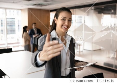 Friendly smiling young businesswoman hr manager show inviting hand gesture 129213010