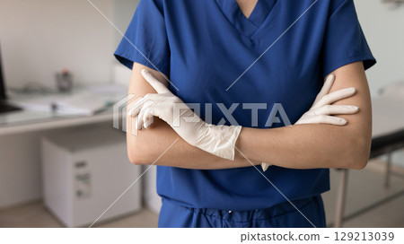 Young surgeon in blue scrubs and rubber gloves cropped shot 129213039
