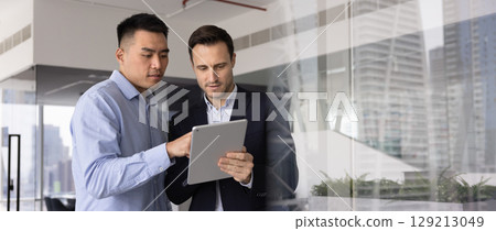 Horizontal image of two professional men working together using tablet Horizontal image of two professional men working together using tablet 129213049