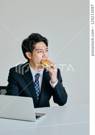 Young man eating a hamburger for lunch Young man eating a hamburger for lunch 129213097