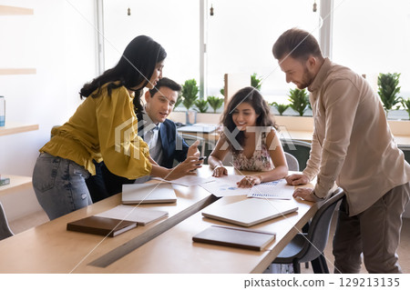 Group of four multiethnic workmates engaged in brainstorming session Group of four multiethnic workmates engaged in brainstorming session 129213135
