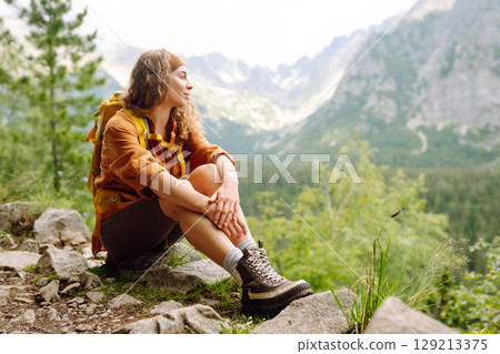 Female legs in hiking boots on hiking trail, on top of mountain outdoors. Nature, relaxation concept 129213375