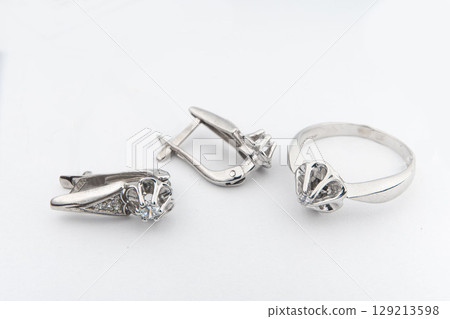 Silver jewelry set of ring and silver earrings with stones on white background. Silver jewelry set collection Silver jewelry set of ring and silver earrings with stones on white background. Silver jewelry set collection 129213598