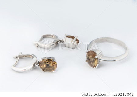 Elegant jewelry set of white gold ring, necklace and earrings with diamonds. Silver jewellery set with gemstones. Product still life concept 129213842