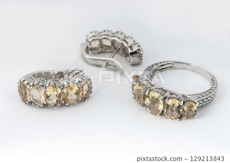 Elegant jewelry set of white gold ring, necklace and earrings with diamonds. Silver jewellery set with gemstones. Product still life concept 129213843