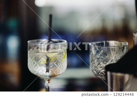 A glass with an unfinished drink in a wine glass at a beach cafe A glass with an unfinished drink in a wine glass at a beach cafe 129214448
