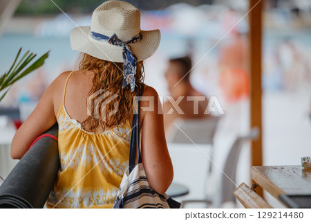 Unrecognizable young woman in light dress with yoga mat in hat and canvas bag Unrecognizable young woman in light dress with yoga mat in hat and canvas bag 129214480