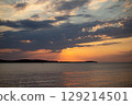 Romantic sunset and sky with calm sea with slight ripples in the background 129214501