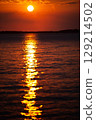 Romantic sunset and sky with calm sea with slight ripples in the background 129214502