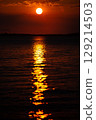 Romantic sunset and sky with calm sea with slight ripples in the background 129214503