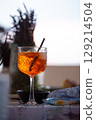 A classic Aperol Spritz cocktail in a glass with a straw sits on inked table 129214504