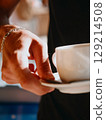 Waiter of summer beach cafe brings cup of coffee to customer. Summer relaxation 129214508