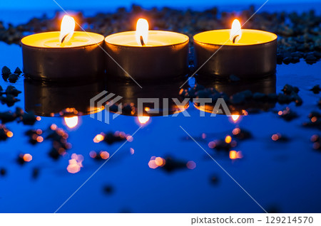 Three tealight candles burn side by side, like tiny sparks of comfort and tenderness Three tealight candles burn side by side, like tiny sparks of comfort and tenderness 129214570