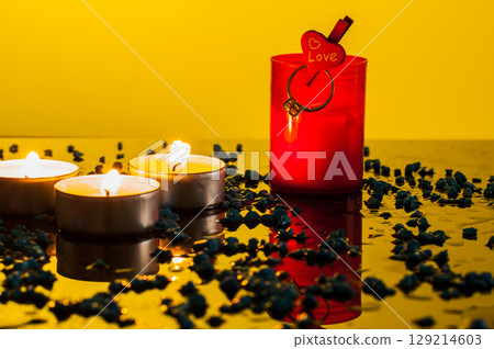 A gold ring for your beloved near small lighted candles A gold ring for your beloved near small lighted candles 129214603