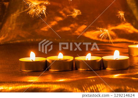 The glow of many burning candles adds coziness to the frame 129214624