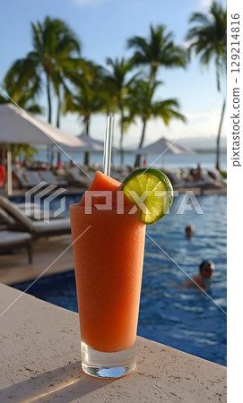 Refreshing Tropical Drink by the Poolside with Palm Trees in Background. Refreshing Tropical Drink by the Poolside with Palm Trees in Background. 129214816