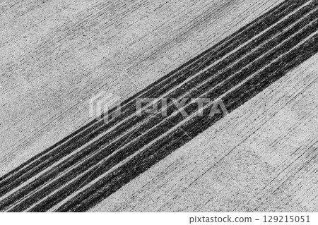 Black tire marks on road, Black rubber tire marks and tread marks, Tire trace track wheels texture and background, Auto tire tread grunge, Car wheel tyre tread track black tyre print, Aerial view. Black tire marks on road, Black rubber tire marks and tread marks, Tire trace track wheels texture and background, Auto tire tread grunge, Car wheel tyre tread track black tyre print, Aerial view. 129215051