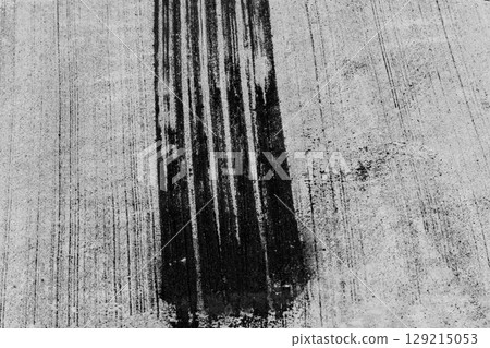 Black tire marks on road, Black rubber tire marks and tread marks, Tire trace track wheels texture and background, Auto tire tread grunge, Car wheel tyre tread track black tyre print, Aerial view. 129215053