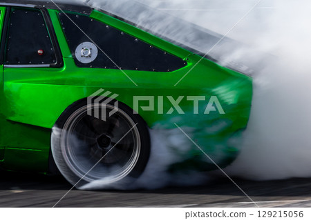 Car drifting, Blurred image diffusion race drift car with lots of smoke from burning tires on speed track, Car drifting on speed track, Professional driver drive drifting car. 129215056