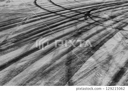 Black tire marks on road, Black rubber tire marks and tread marks, Tire trace track wheels texture and background, Auto tire tread grunge, Car wheel tyre tread track black tyre print, Aerial view. Black tire marks on road, Black rubber tire marks and tread marks, Tire trace track wheels texture and background, Auto tire tread grunge, Car wheel tyre tread track black tyre print, Aerial view. 129215062