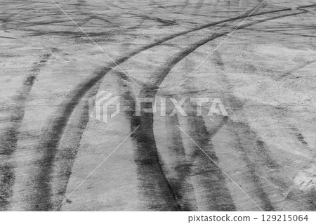Black tire marks on road, Black rubber tire marks and tread marks, Tire trace track wheels texture and background, Auto tire tread grunge, Car wheel tyre tread track black tyre print, Aerial view. 129215064