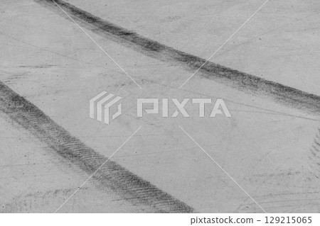 Black tire marks on road, Black rubber tire marks and tread marks, Tire trace track wheels texture and background, Auto tire tread grunge, Car wheel tyre tread track black tyre print, Aerial view. 129215065