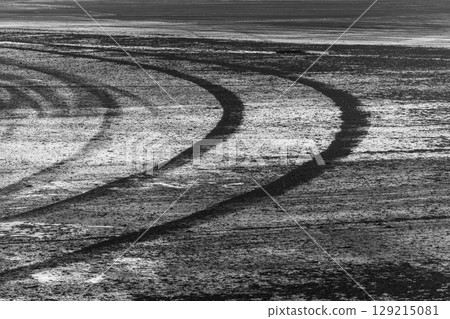 Black tire marks on road, Black rubber tire marks and tread marks, Tire trace track wheels texture and background, Auto tire tread grunge, Car wheel tyre tread track black tyre print, Aerial view. Black tire marks on road, Black rubber tire marks and tread marks, Tire trace track wheels texture and background, Auto tire tread grunge, Car wheel tyre tread track black tyre print, Aerial view. 129215081