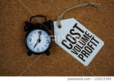 Cost Volume Profit text on price tag with alarm clock on cork board background 129215394