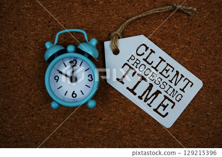 Client Processing Time text on price tag with alarm clock on cork board background 129215396