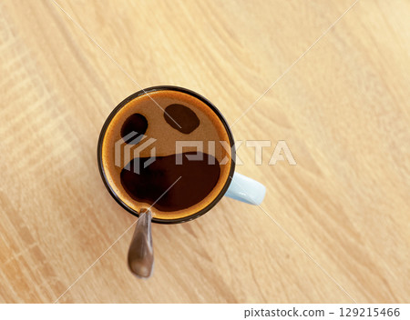 Coffee cup with funny screaming in fear face, top view. Pareidolia effect at breakfast Coffee cup with funny screaming in fear face, top view. Pareidolia effect at breakfast 129215466