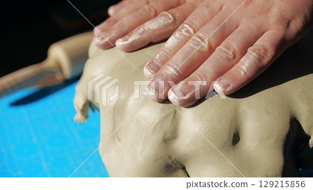 A potter makes the artisanal ceramic plate with rolled clay and drape mold, close-up A potter makes the artisanal ceramic plate with rolled clay and drape mold, close-up 129215856