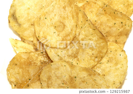 Close up of fresh potato seasoned crisps snack on a white background 129215987