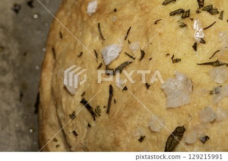 Close up of home made focaccia bread ready baked in the oven with rosemary Close up of home made focaccia bread ready baked in the oven with rosemary 129215991
