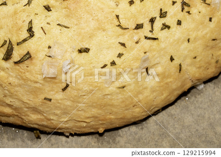 Close up of home made focaccia bread ready baked in the oven with rosemary Close up of home made focaccia bread ready baked in the oven with rosemary 129215994