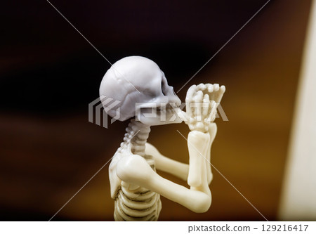 Praying skeleton figurine and sunlight. Namaste or Namaskar prayer hand gesturing and sunbeam Praying skeleton figurine and sunlight. Namaste or Namaskar prayer hand gesturing and sunbeam 129216417