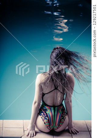Woman back in swimsuit on pool edge. Woman back in swimsuit on pool edge. 129217501