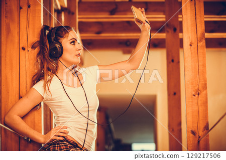 Woman with headphones smartphone listening music. 129217506