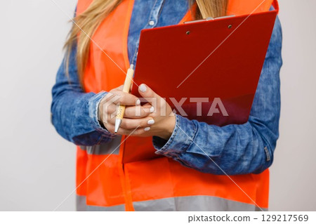 Woman engineer construction builder holds file pad. 129217569