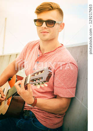 Trendy guy with guitar outdoor 129217663