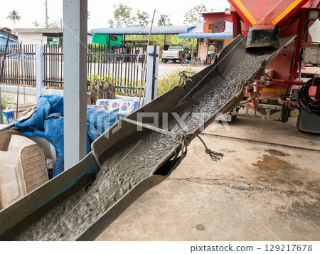 Concrete Pouring from Red Mixer Truck Chute. 129217678