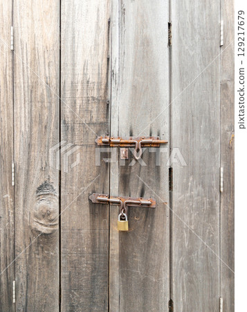 Rusty Padlock on Aged Wooden Door. 129217679