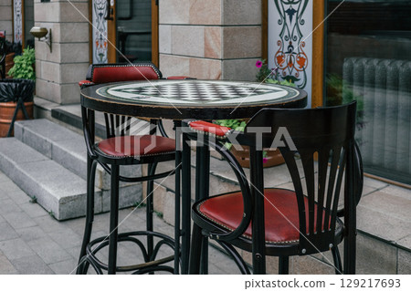 outdoor cafe with stylish high tables and chairs inviting to enjoy your vacation in urban setting. outdoor cafe with stylish high tables and chairs inviting to enjoy your vacation in urban setting. 129217693